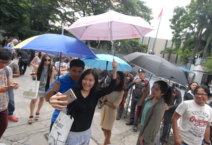 Activists hold umbrellas in front of the Chinese embassy Wednesday in Bangkok to protest the deportation of Hong Kong activist Joshua Wong, reportedly at the request of mainland China.