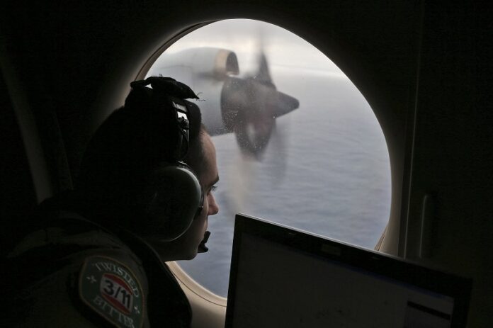 Flight officer Rayan Gharazeddine scans the water in 2014 in the southern Indian Ocean off Australia from a Royal Australian Air Force AP-3C Orion during a search for the missing Malaysia Airlines Flight MH370. Photo: Rob Griffith / Associated Press