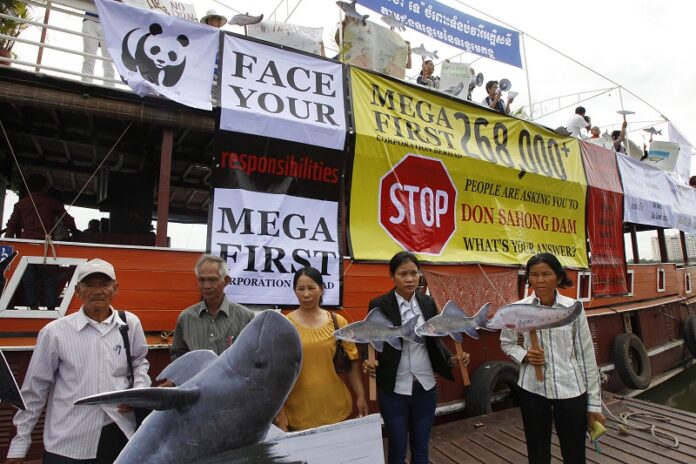 Cambodian non-governmental organization (NGOs) activists hold a cut-out of Mekong dolphin, left, and cut-out of other species during a protest against a proposed Don Sahong dam in 2014 in Phnom Penh, Cambodia. Photo: Heng Sinith / Associated Press