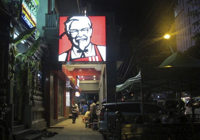 A sign of KFC’s grinning Colonel Sanders and his goatee is lit outside its outlet Oct. 7 in Yangon, Myanmar. Photo: Elaine Kurtenbach / Associated Press