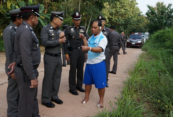 Paisan U-khum, 44, talks to police at the scene where he was robbed by three men in military uniforms Saturday in the northeastern province of Mukdahan. 