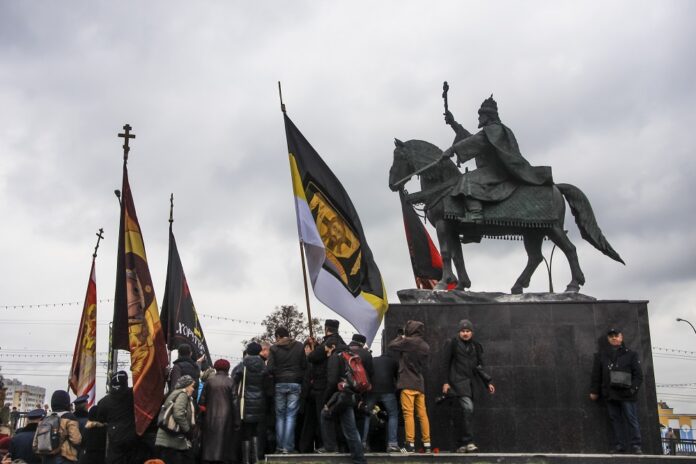 People hold various flags of Russian patriotic and Orthodox movements at the unveiling ceremony for a monument to Czar Ivan the Terrible in the city of Orel, 350 kilometers south of Moscow, on Friday. Photo: Howard Amos / Associated Press