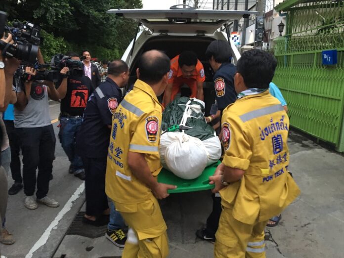 Rescue workers load a body found in a Phra Khanong shophouse on Sept. 23 in Bangkok. Police now believe the body was that of an American man named Charles Edward Ditlefsen.