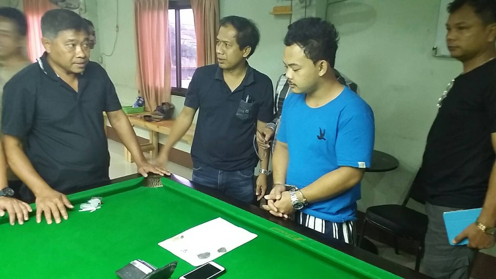 Chaiwat Prangmat, in blue, being apprehended at a sports club at Nakhon Nayok Thursday night.