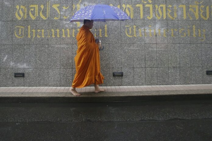 Buddhist monks, mourners, activists and others gathered Thursday to mark the 40th anniversary of one of the darkest days in Thailand's history, when police killed scores of university students at a peaceful protest, and ghoulish vigilantes defiled the dead. Photo: Sakchai Lalit / Associated Press
