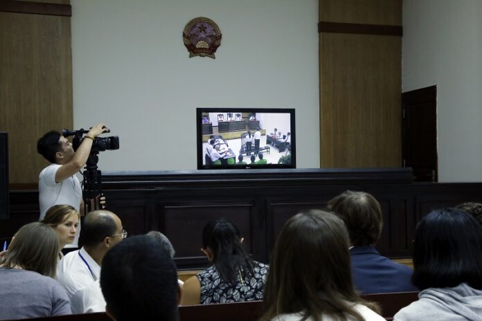 Media and diplomats watch a live screen last September showing another prominent blogger Nguyen Huu Vinh, right, and his colleague Nguyen Thi Minh Thuy, left, another couple to have been tried for online offenses in an appeals court in Hanoi, Vietnam. Photo: Tran Van Minh / Associated Press