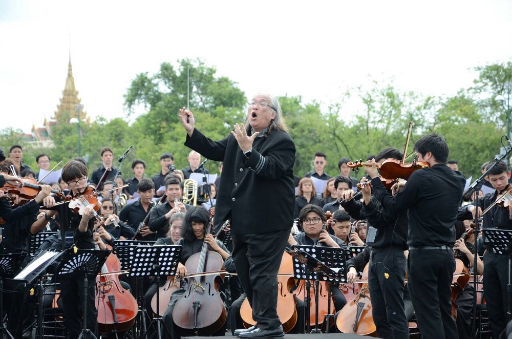 Conducter Somtow Sucharitkul leads musicians Saturday in the Sanam Luang in Bangkok.