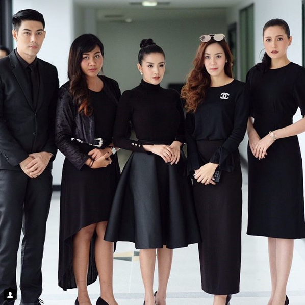 Luk thung singer Suteewan ‘Baitoey’ Taveesin, center, and friends pose Monday in mourning clothes.