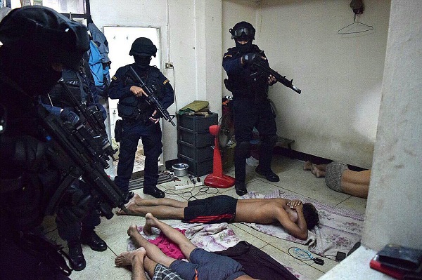 SWAT team members raid an apartment building in Bangkok’s Ramkhamhaeng area Tuesday. They arrested eight men on drug-related charges.