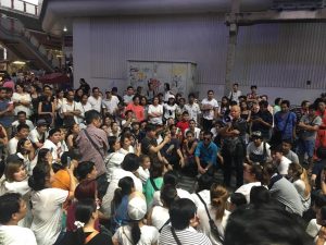 Retired police officer Prapoj Bootanaphalit addresses protesting vendors through a megaphone Wednesday evening in Bangkok.