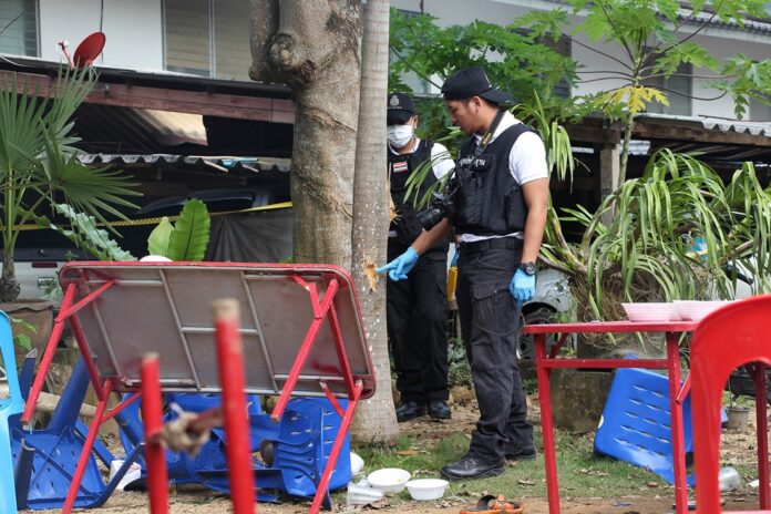 A forensic police officer on Wednesday examines a bullet hole allegedly left by Cpl. Hassapol Soprakon’s assault rifle at Batutamong Police Station.