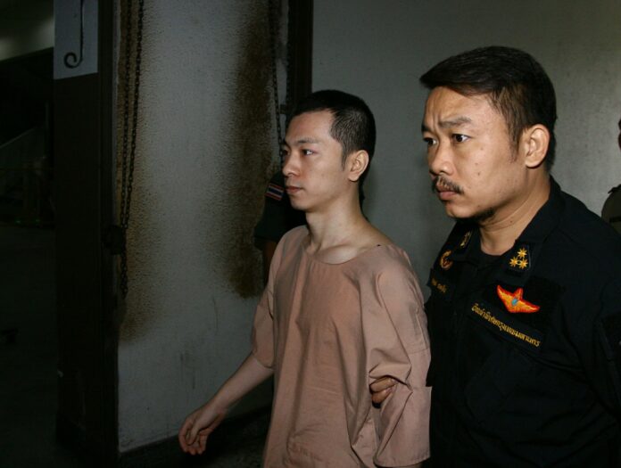 Yang Zheng, at left, is led Tuesday morning to the Ratchadapisek Criminal Court in Bangkok.