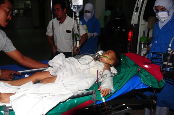 Rescue workers rush Peerapat Laipraditporn, 3, into surgery Thursday night in Narathiwat province.