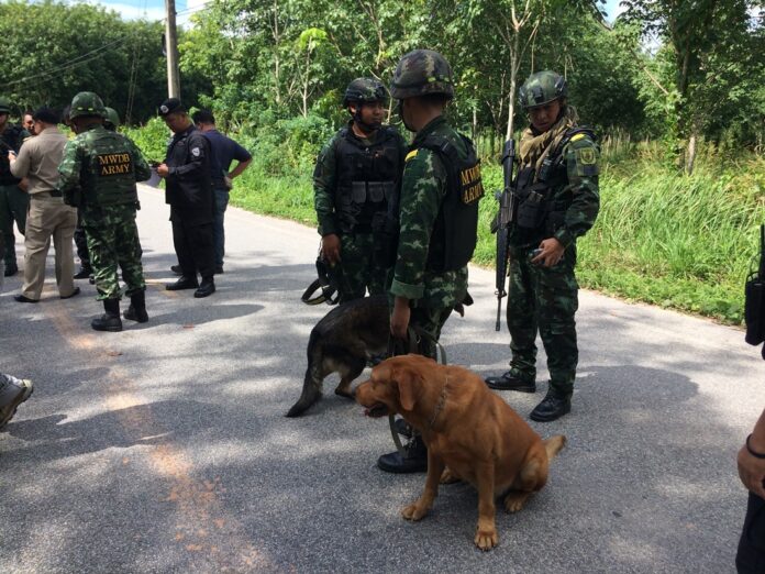 Police and military officers scour the site of a bombing Monday in Pattani province for evidence.