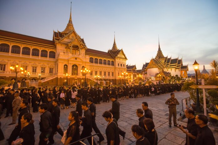 Mourners line up at sunset on Tuesday to pay respect to the royal coffin of His Majesty the Late King at Grand Palace in Bangkok