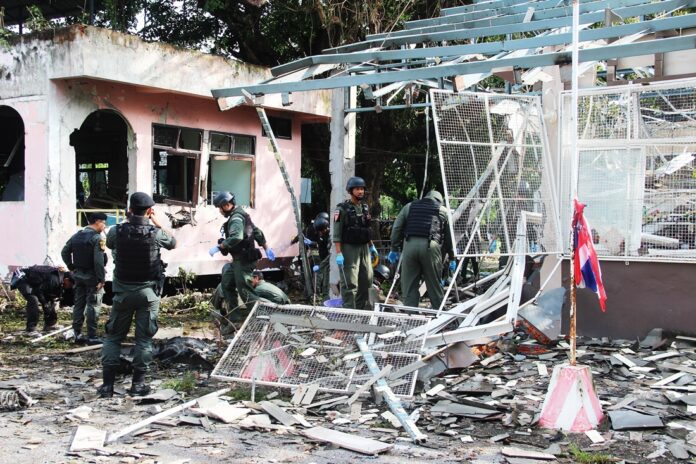 Security officers comb the wreckage of a gas station for evidence Friday morning after it was hit by a car bomb.