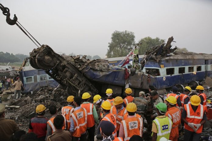 Rescuers search among the debris after 14 coaches of an overnight passenger train rolled off the track Sunday near Pukhrayan village Kanpur Dehat district, Uttar Pradesh state, India. Photo: Rajesh Kumar Singh / Associated Press
