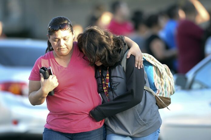 A parent picks up her daughter at Slauson Middle School that was on lockdown as Azusa police and other agencies respond to a shooting Tuesday near Fourth Street and Orange Avenue in Azusa, California. Photo: Keith Durflinger / Associated Press