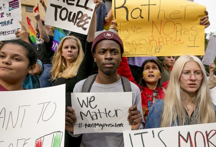 From left, Celeste Ramirez, 20, Erin Ckodre , 21, Ronald Elliott, 18, Patricia Romo, 22, and Rose Ammons, 18, hold up signs Thursday during a rally at Texas State University in San Marcos, Texas, to protest Donald Trump's presidential election victory. Photo: Jay Janner / Associated Press