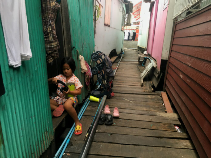 A child sits in the doorway of her soon-to-be-demolished home built over the Chao Phraya River on Monday in Bangkok.