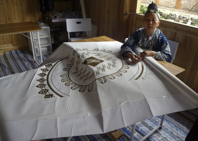 Ethnic minority artisan Pan Xiu-ying uses wax to make a batik pattern on a scarf Aug. 7 in rural Sandu in China's Guizhou province. Photo: Kelvin Chan / Associated Press