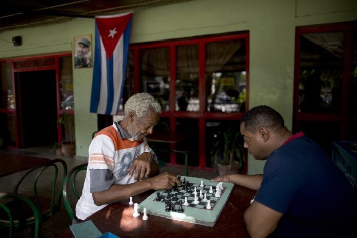 Men play chess at a bar Monday near Revolution Plaza, the site of two days of tributes to the late Fidel Castro, in Havana, Cuba. Photo: Natacha Pisarenko / Associated Press
