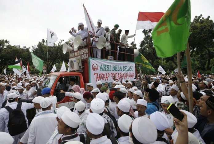 Muslim protesters gather in October with a banner calling for the arrest of Jakarta's ethic Chinese and Christian Governor Basuki Tjahaja Purnama, popularly known as