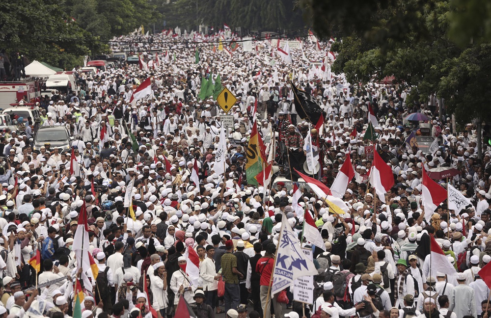 Muslim protesters march Friday during a demonstration in Jakarta, Indonesia. Tens of thousands of hard-line Muslims converged Friday on the center of the Indonesian capital to demand the arrest of its minority-Christian governor for alleged blasphemy. Photo: Achmad Ibrahim / AP