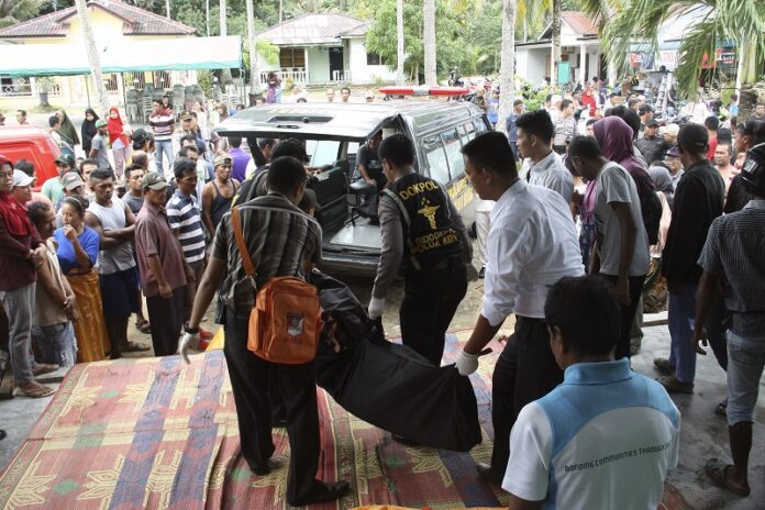Indonesian police officers carry the body of a victim in the capsizing of a speedboat last year in Batam, Indonesia. Photo: M Urip / Associated Press