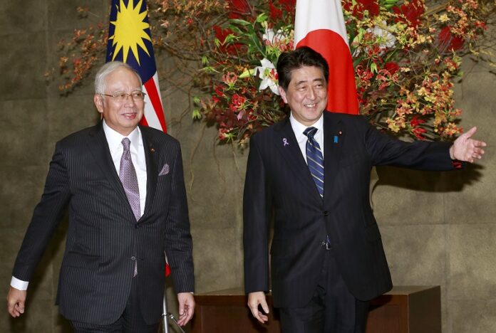 Malaysian Prime Minister Najib Razak, left, is shown the way by Japanese Prime Minister Shinzo Abe Wednesday prior to a meeting at Abe's official residence in Tokyo. Photo: Shizuo Kambayashi / Associated Press