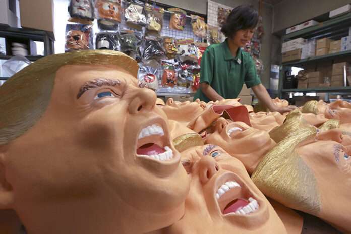 A worker puts the final touches on rubber masks depicting President-elect Donald Trump on Tuesday at the Ogawa Studio in Saitama, north of Tokyo. Photo: Eugene Hoshiko / Associated Press