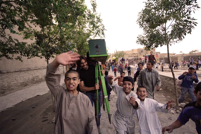 Landry Dunand carrying his camera obscura while walking along with Afghan children in Kabul in 2007. Photo: Landry Dunand / Courtesy 