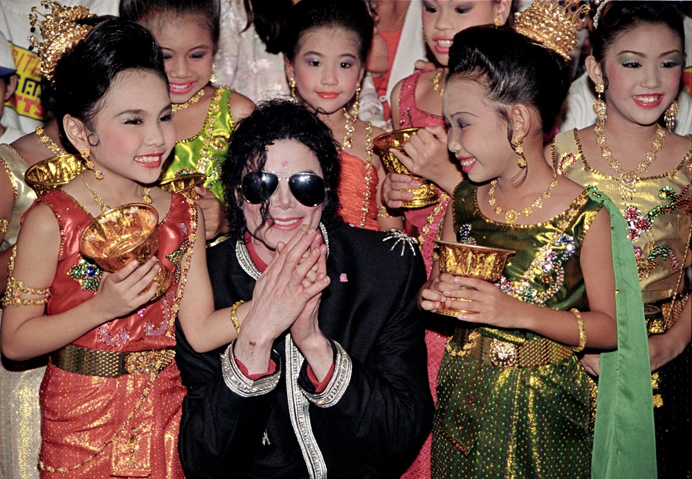 Michael Jackson is greeted by children in traditional dress as he arrives ahead of his 1996 concert in Bangkok. Photo: Charles Dharapak / Associated Press 