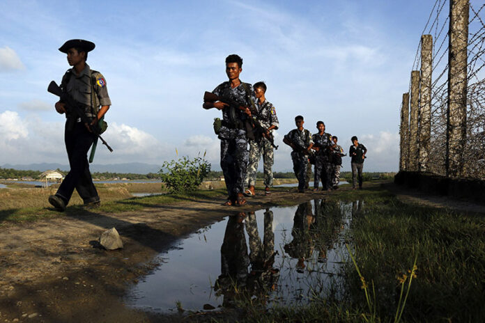 Myanmar police officers patrol the border fence between Myanmar and Bangladesh on Oct. 14, 2016, in Maungdaw, Rakhine State, Myanmar. Photo: Thein Zaw / Associated Press