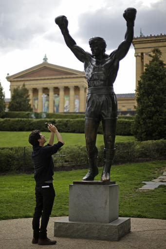 A tourist photographs a statue of the movie character Rocky Balboa outside the Philadelphia Museum of Art in Philadelphia, 2013. Photo: Matt Rourke / AP