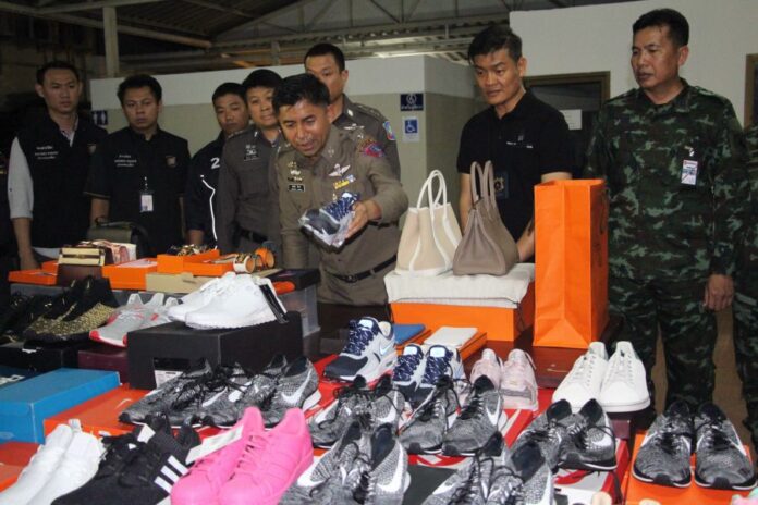 Police with goods seized Sunday from Prisanan Pongpipatwet’s tax-free Instagram shop.
