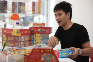 Note holding Halli Galli, a speed-based fruit-matching game, and surrounded by Settlers of Catan. 