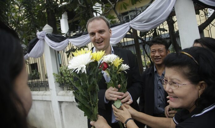 Supporters give flowers to British human rights activist Andy Hall in 2016 at the Supreme Court in Bangkok. Photo: Sakchai Lalit / Associated Press