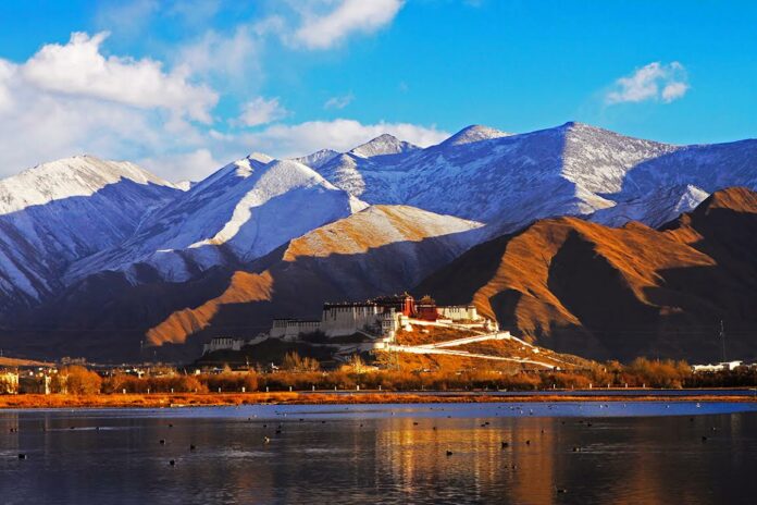 The Tibetan Potala Palace sits beneath the enormity of Mt. Everest. Photo: Xinhua News Agency / Courtesy