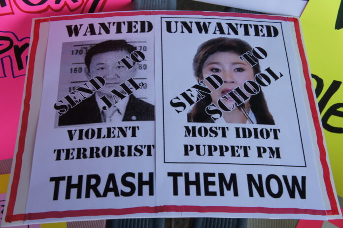 A sign calls for former PMs Thaksin Shinawatra, at left, and his sister Yingluck Shinawatra to be jailed for corruption at a protest in New York City in September 2012. Image: PAD New England