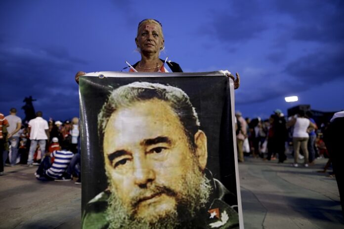 A woman holds a picture of Fidel Castro Saturday before a rally honoring Cuba's late leader at Antonio Maceo plaza in Santiago, Cuba. Photo: Natacha Pisarenko / Associated Press