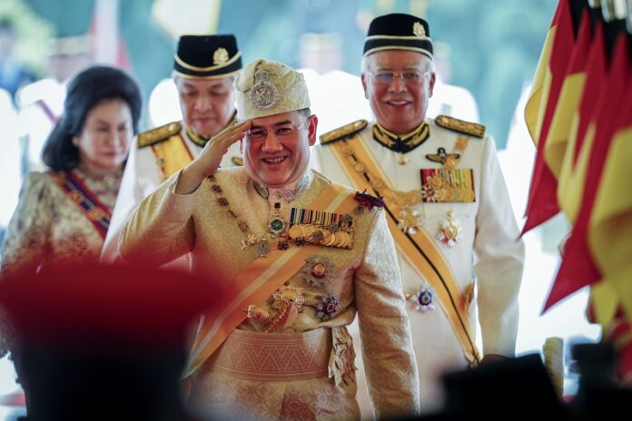 Sultan Muhammad V, center, salutes after his welcome ceremony as he walks with Malaysian Prime Minister Najib Razak, right, in 2016 at the Parliament House in Kuala Lumpur, Malaysia. Photo: Vincent Thian / Associated Press