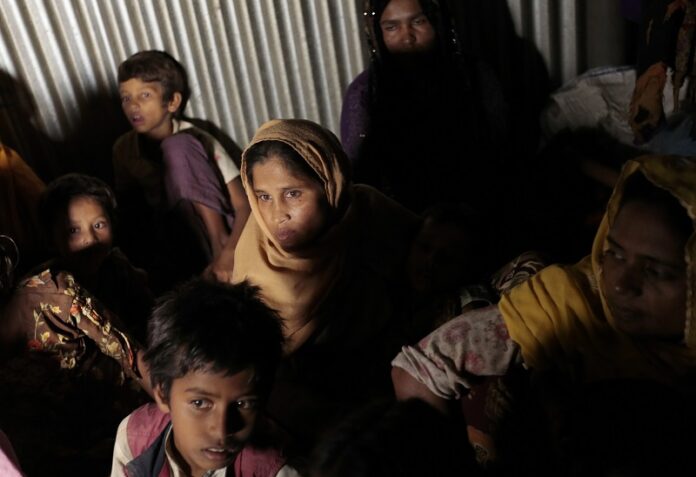 Rohingya from Myanmar who recently crossed over to Bangladesh, huddle in a room Friday at an unregistered refugee camp in Teknaf, near Cox's Bazar, a southern coastal district about, 296 kilometers (183 miles) south of Dhaka, Bangladesh. Photo: A.M. Ahad / Associated Press