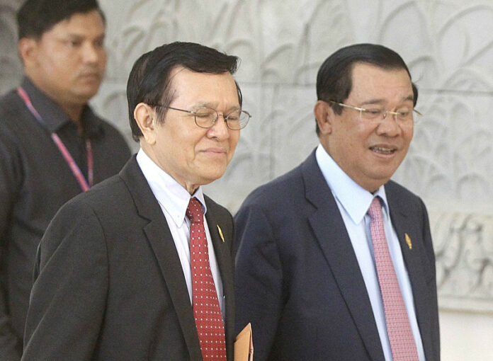 Cambodia's Prime Minister Hun Sen, right, walks together with opposition Cambodia's Rescue Party Deputy President Kem Sokha, center in 2016 during a break at National Assembly in Phnom Penh, Cambodia. Photo: Heng Sinith / Associated Press