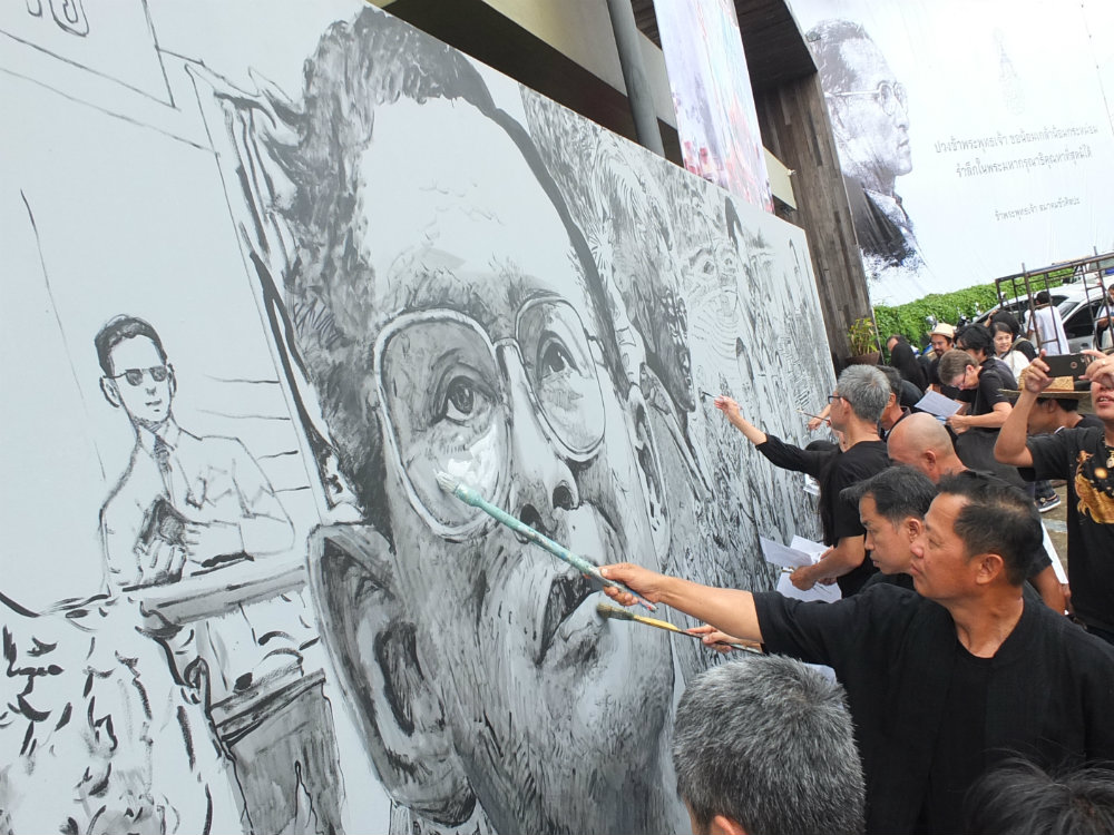 Outspoken artist Chalermchai Kositpipat leads Chiang Rai artists to draw an image of King Rama IX on a 17 meter canvas on Oct. 24. Photo: Matichon