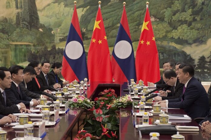 Laotian Prime Minister Thongloun Sisoulith, second left, and China's President Xi Jinping, right, attend their meeting Dec. 1 at the Great Halll of the People in Beijing. Photo: Nicolas Asfouri / Associated Press