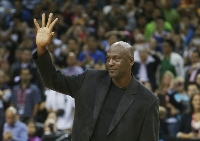 NBA basketball legend Michael Jordan waves during the match of Charlotte Hornets against the Los Angeles Clippers at the 2015 NBA Global Games in Shenzhen, south China's Guangdong province. Photo: Kin Cheung / AP.