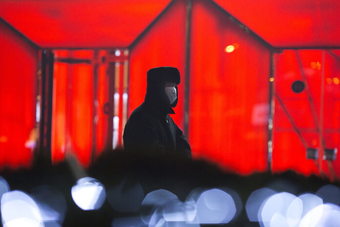 A security guard wears a mask Saturday in Beijing. Photo: Ng Han Guan / Associated Press