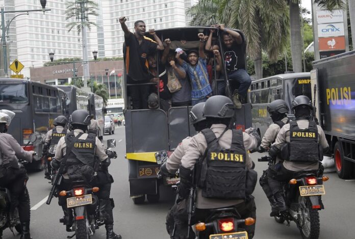 West Papuan protesters shout slogans as they are taken away on a police truck under armed police escort Thursday during a rally calling for the remote region's independence, in Jakarta, Indonesia. Photo: Dita Alangkara / Associated Press