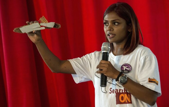 Grace Nathan, of Malaysia, whose mother was on board the missing Malaysian flight MH370, shows how a debris piece looks like during a media conference Monday in Antananarivo, Madagascar. Photo: Alexander Joe / Associated Press